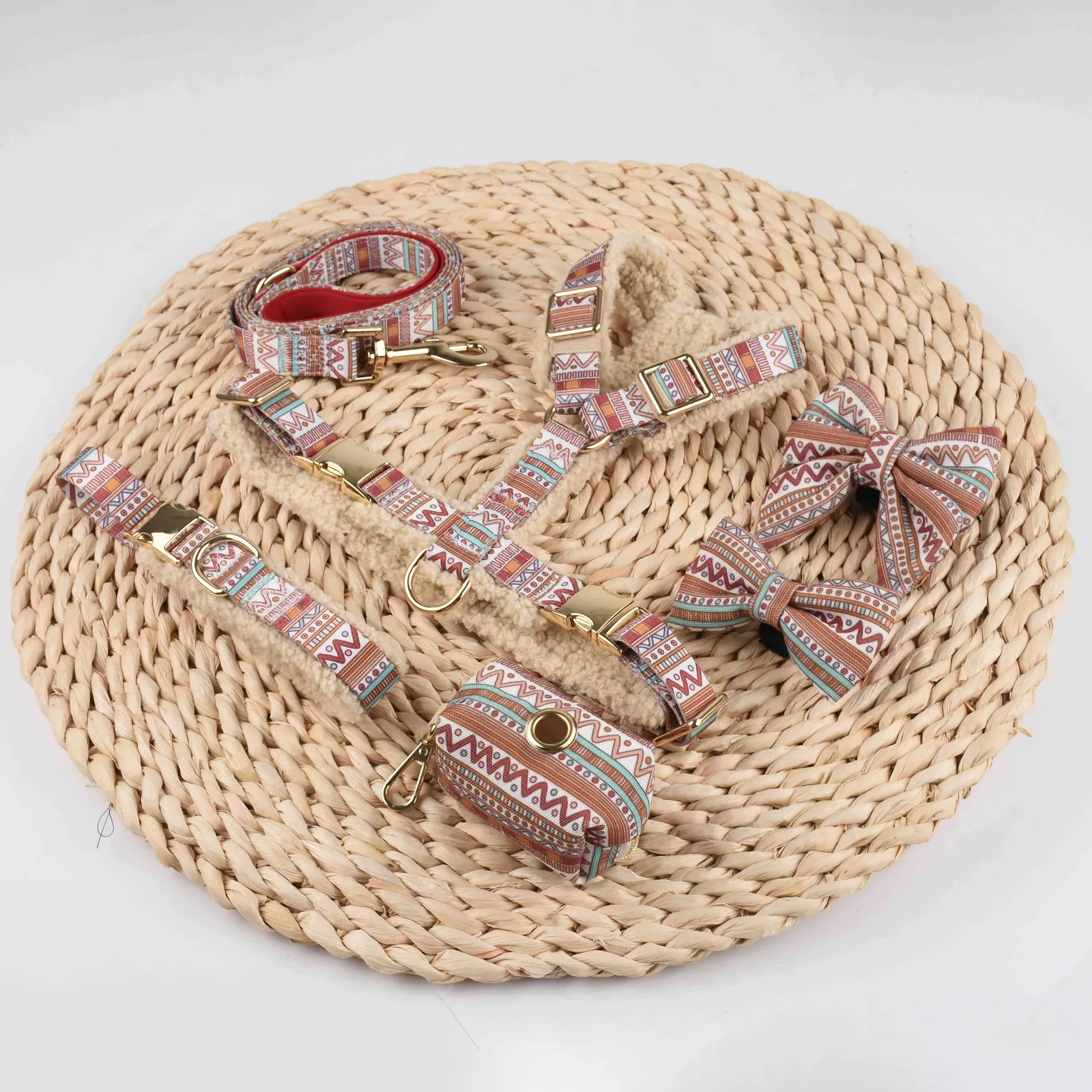 Cream teddy fleece dog harness set on a round woven mat, with collar, leash and patterned bow ties